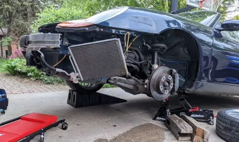 Porsche Boxster with the wheel off, repairing the radiator mount